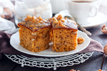 Homemade pie with nuts and raisins boiled condensed milk on a white plate, cut into squares, horizontal