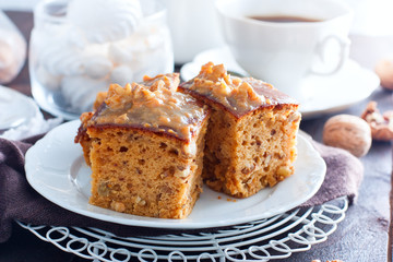 Homemade pie with nuts and raisins boiled condensed milk on a white plate, cut into squares, horizontal