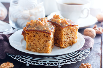Homemade pie with nuts and raisins boiled condensed milk on a white plate, cut into squares, horizontal