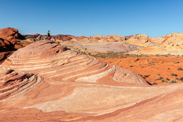 A woman over Fire Wave rock in Valley of Fire State Park, Nevada, USA