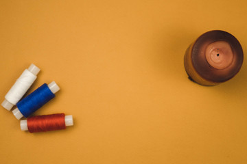 red white and blue threads on an orange background