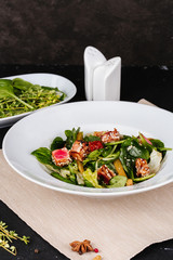 Salad with corn, meat, salmon, green leaves, tomatoes, oil and spices