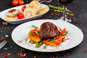Fried pork with vegetables: green beans, carrots, paprika, garlic, greens, tomato and a glass of red wine,