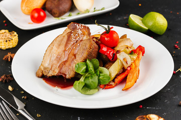 Fried pork with vegetables: green beans, carrots, paprika, garlic, greens, tomato and a glass of red wine,