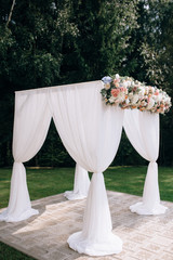 Arch for the wedding ceremony, decorated with cloth and flowers