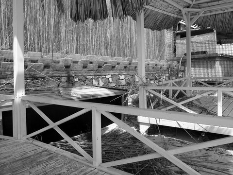 Schattige Strandh&uuml;tten aus Holz mit Bastmatten im Sommer bei Sonnenschein am Strand in der Bucht von Alacati bei Cesme am &Auml;g&auml;ischen Meer in der Provinz Izmir in der T&uuml;rkei in klassischem Schwarzwei&szlig;