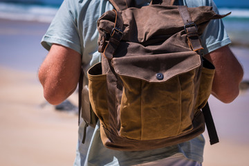 Travel and vacation lifestyle concept with man and leather vintage backpack viewed from rear - sku...