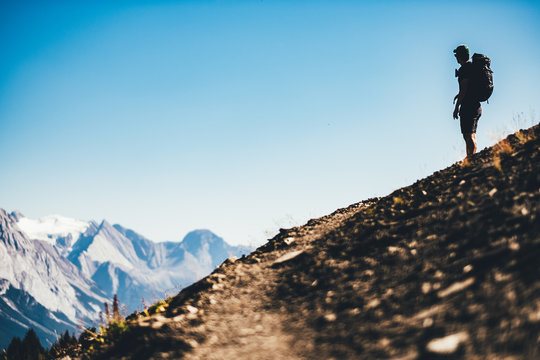 Ein Wanderer geniesst die Aussicht auf die Berge und das Tal 