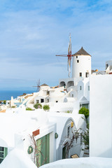 Fototapeta na wymiar Traditional white windmill in Oia on Cyclades island of Santorini, Greece