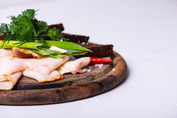 Lard, black bread and greens on a wooden board on a white background. Copy space.