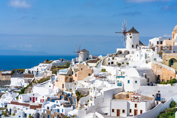 View of Oia town with traditional white windmills on Cyclades island of Santorini, Greece