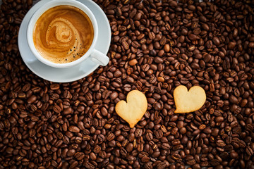Two heart shaped cookies with espresso coffee