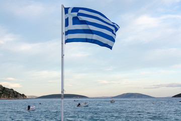 Fototapeta premium National symbol of Greece, blue-white greek flag, sea water and blue sky, copy space