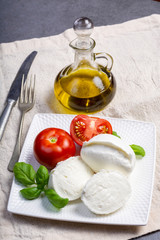 Soft white Italian cheese Mozzarella buffalo served with fresh tomato, olive oil and green basil leaves