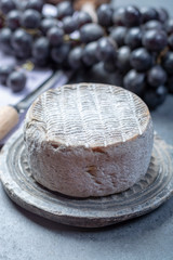 Whole round mature French Tomme cheese close up