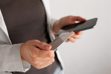 mobile payment and safe online transactions. digital finance and electronic operations. Woman holding credit card and phone.