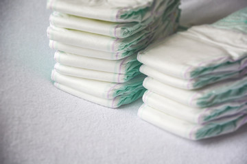 Group of disposable diapers arranged over a white changing table