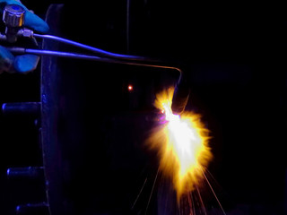 Fototapeta na wymiar Welding parts, worker heats the detail of a gas torch