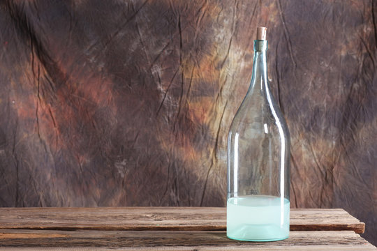 The Bottle And Glass Of Moonshine On The Old Wooden Table