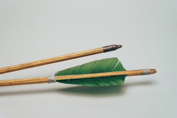 Old wooden arrow. Beautiful gray background. Medieval weapons are handmade.