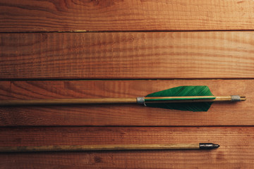 Old wooden arrow. Beautiful wooden table background. Medieval weapons are handmade.