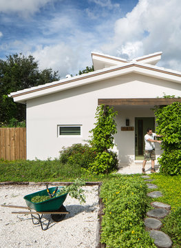 Solar House with Permaculture Man Working