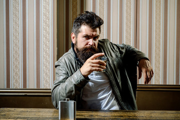 Man with beard holds glass brandy. Man holding a glass of whisky. Handsome stylish bearded man is...