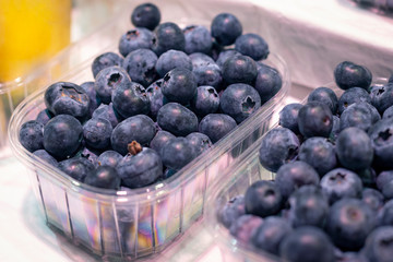 Big fresh ripe organic natural blueberry in package on the showplace in the market
