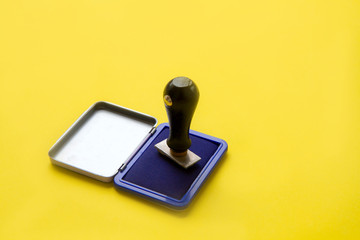 Stamper with blue ink on yellow background