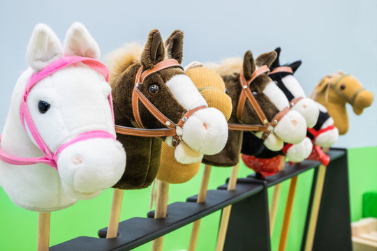 Row of multicolored hobbyhorses - children toys.