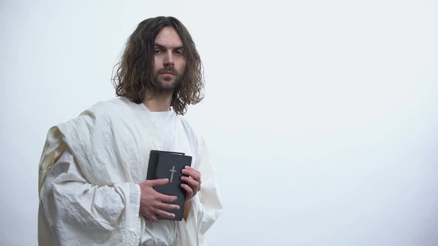 Jesus showing Holy Bible to camera, calling for prayer, Christian teachings