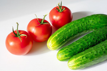 Close-up of fresh, ripe tomatoes and cucumbers on a wood background