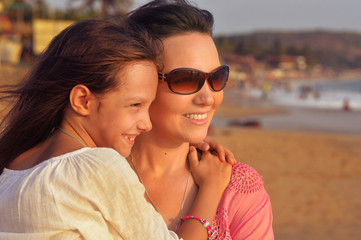 Portrait of mother with daughter on beach