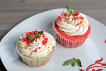 Red velvet cupcake. The finished cakes are on the plate. Decorated with mint leaves.