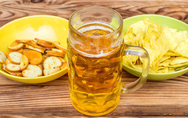 Beer with snacks for beer on wooden table.