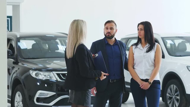 Young people buy a car and talk with the Manager of a trading Hall