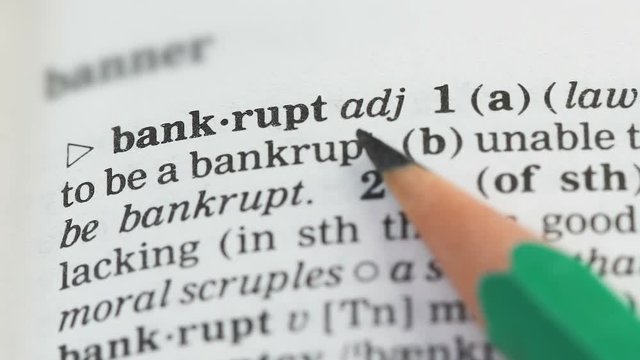 Bankrupt word in english dictionary pointed with pencil, market failure collapse