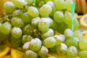 Green grapes with powdered sugar. Fruit dessert