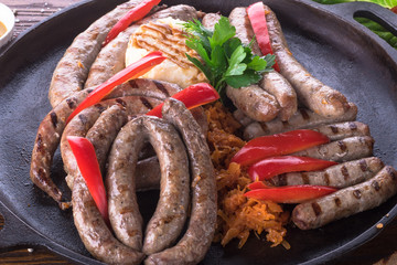 Large plate with different sausages grilled with mashed potatoes and sauerkraut