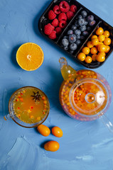 Vitamin healthy sea buckthorn tea in glass cups with fresh raw sea buckthorn berries