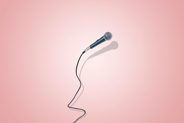 microphone levitating in the air, image over pink background, the concept of accessories for singing