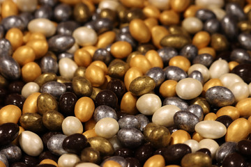 Colorful candy, selective focus. Gold, silver, chocolate and pearl sweets, pile of candies for background