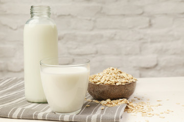 Oat milk and rolled oats. Organic vegan non-dairy plant-based milk in a glass.