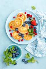 Cottage cheese pancakes, syrniki with fresh berries for breakfast