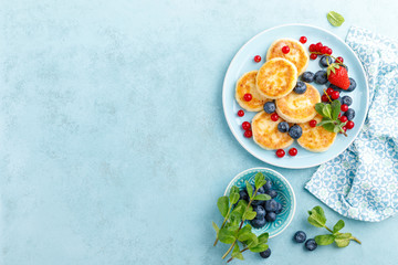 Cottage cheese pancakes, syrniki with fresh berries for breakfast