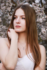 Naklejka premium Young christian girl stay in cherry garden