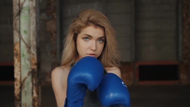 Young fitness girl with bloxing gloves looking at camera over background portrait young student girls happy smiling sport