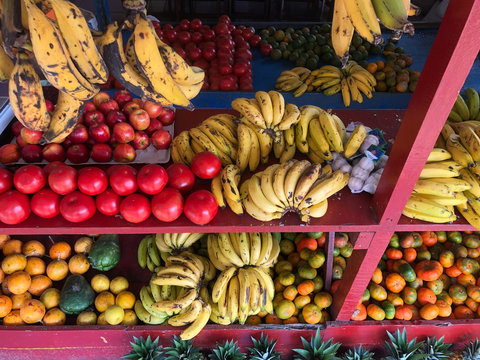 Bananas tomatoes apples and various other fruit ready for sale at a Central American fruit stand