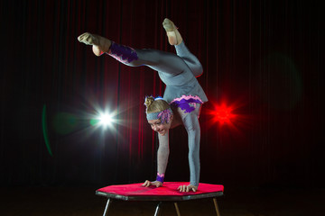 A girl with a flexible body. Performs a circus artist. Circus gymnast. Balancing act. The child performs an acrobatic trick © Светлана Лазаренко