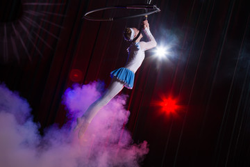Performs a circus girl actress. Circus aerial gymnast on the hoop. Acrobatics. Teenager performs an...